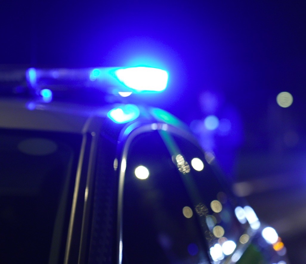Photograph of a police car with blue lights illuminated
